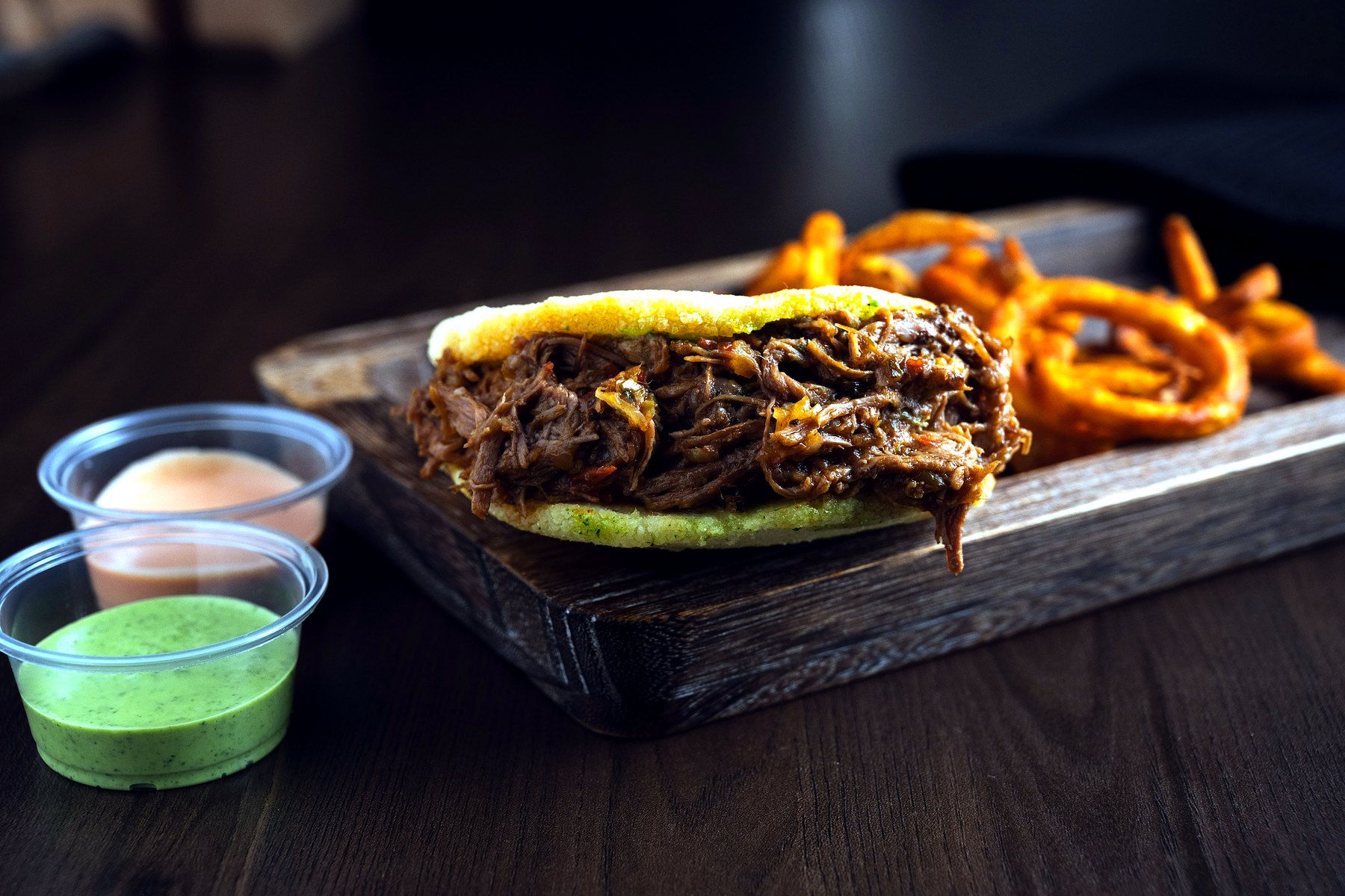 Arepa stuffed with shredded beef and dipping sauces